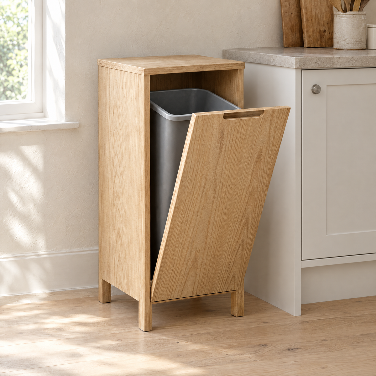 Natural ash tilt-out bin cabinet at the end of a kitchen run