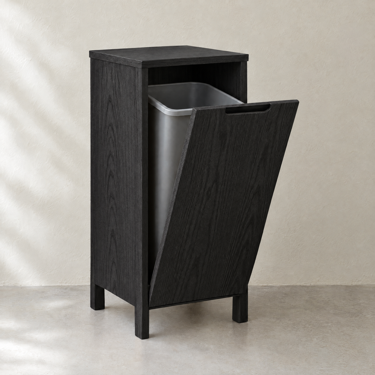Single tilt-out bin cabinet in black-stained ash with the door tilted open