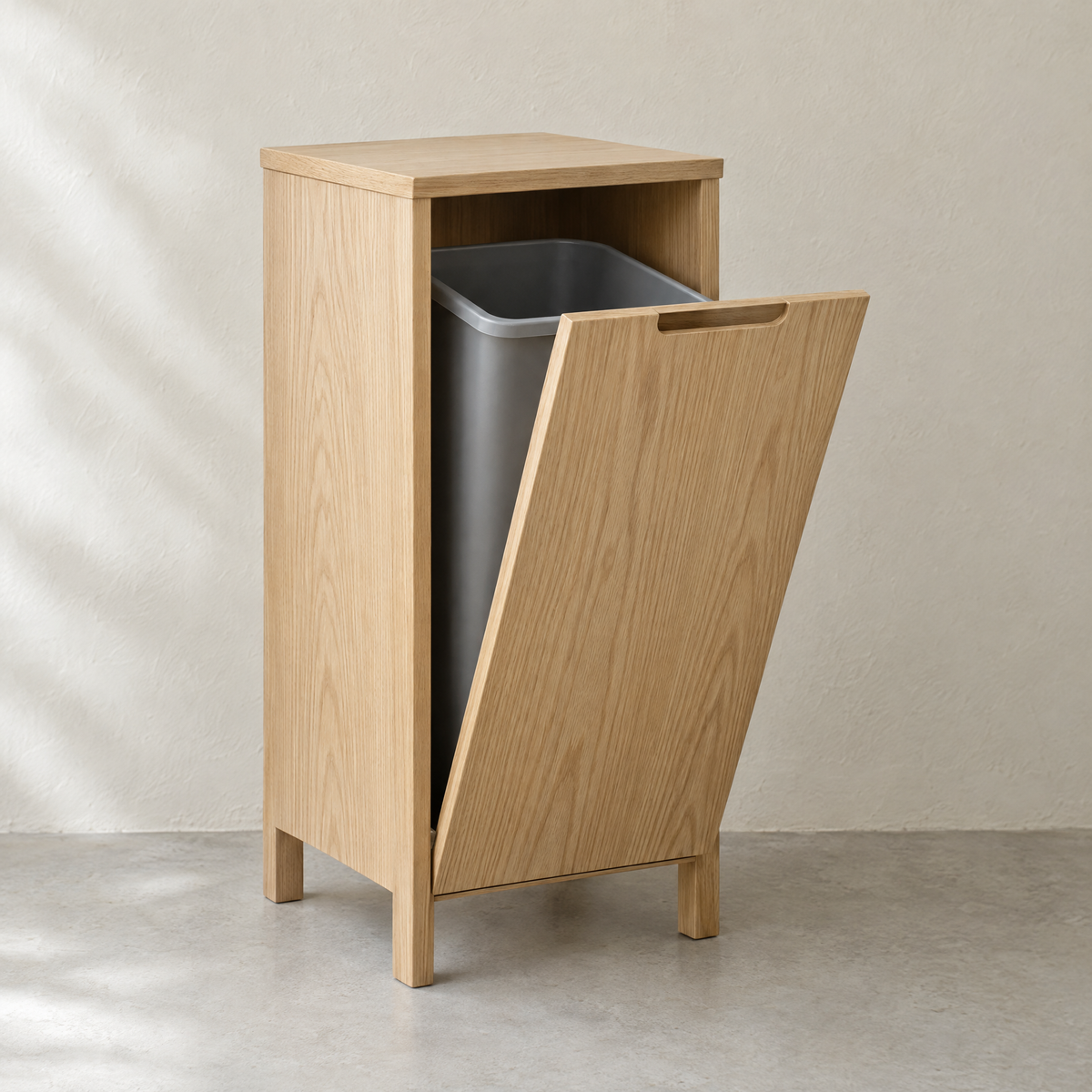 Single tilt-out bin cabinet in natural oiled ash with the door tilted open
